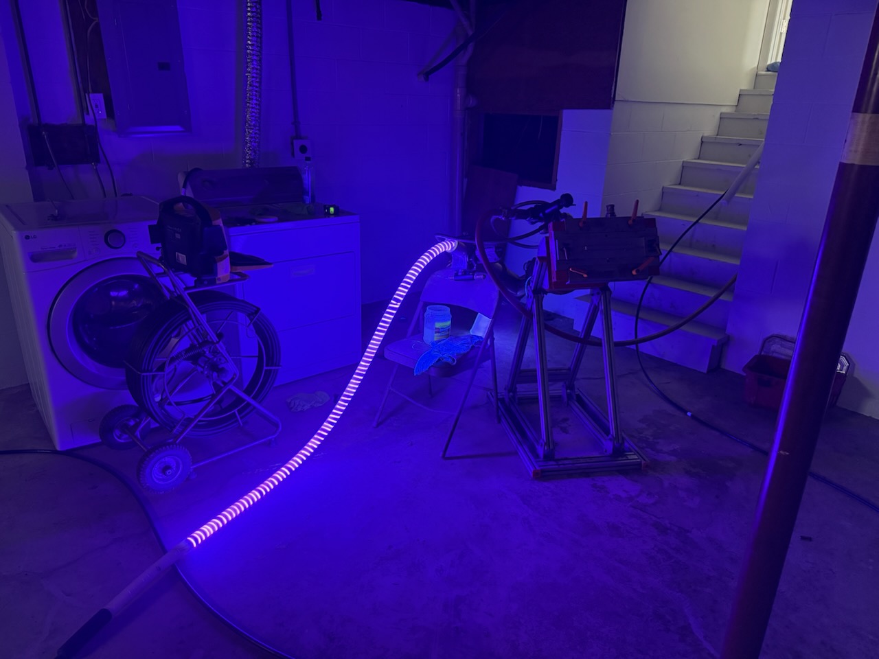 UV-cure CIPP installation in a Central Ohio basement — light train curing the resin liner inside the existing pipe, no excavation